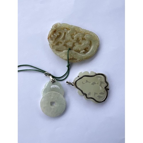 496 - Three Chinese jade coloured pendants, one with metal mounting and two others.