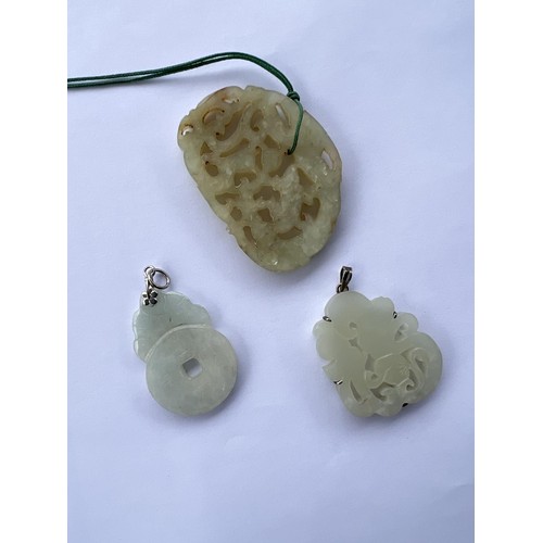 496 - Three Chinese jade coloured pendants, one with metal mounting and two others.