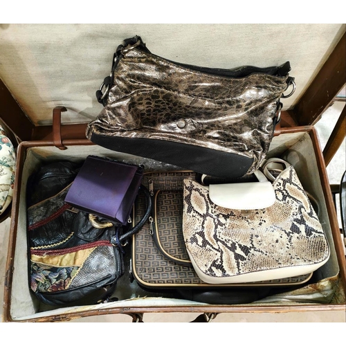 274 - A vintage leather suitcase, bears initials 'J.E.M.', with stickers; a selection of handbags; etc.