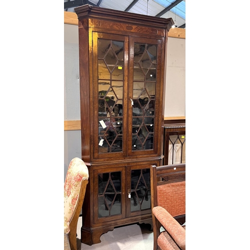 950 - A Georgian mahogany floor standing corner cabinet with moulded cornice and inlaid frieze, enclosed b... 