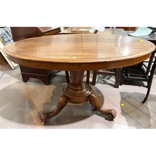 957 - An oval tilt top mahogany supper table with base, 121cm.