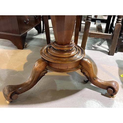 957 - An oval tilt top mahogany supper table with base, 121cm.