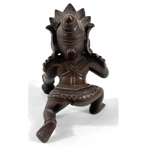 379 - A 19th century Indian bronze weight depicting Chrishna kneeling, height 9cm