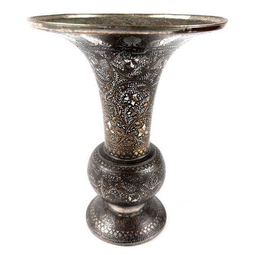 390 - An Indian bronze vase with silver/gilt highlights, flared rim, bulbous body and wide foot