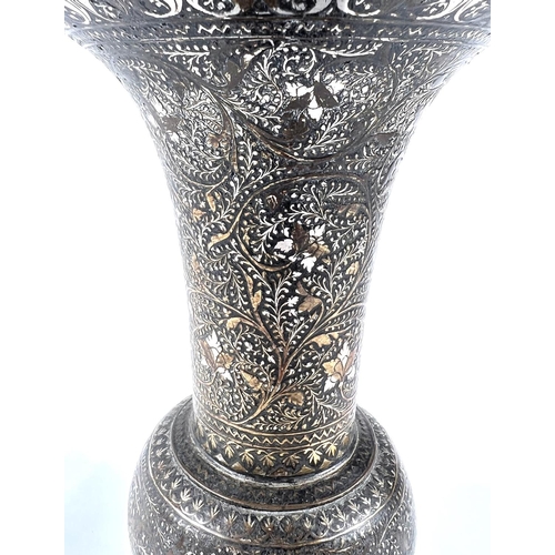 390 - An Indian bronze vase with silver/gilt highlights, flared rim, bulbous body and wide foot