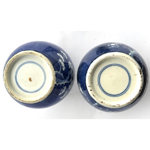 405 - A pair of Chinese blue and white prunus blossom ginger jars with matched lids, both with double circ... 