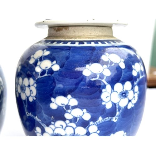 405 - A pair of Chinese blue and white prunus blossom ginger jars with matched lids, both with double circ... 