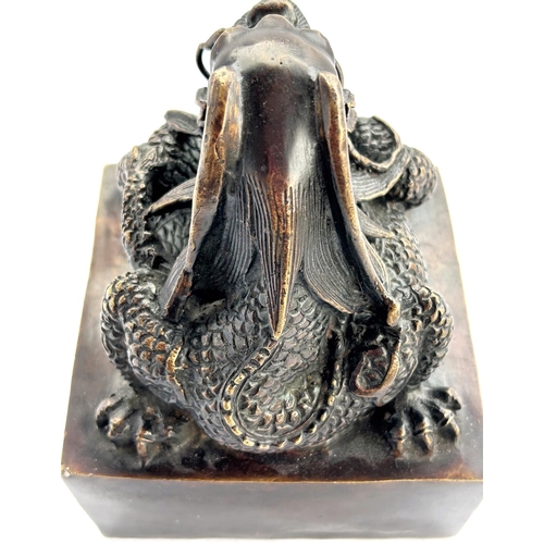 430 - A large Chinese bronze seal with dragon sat on top and seal mark to base, ht 16cm