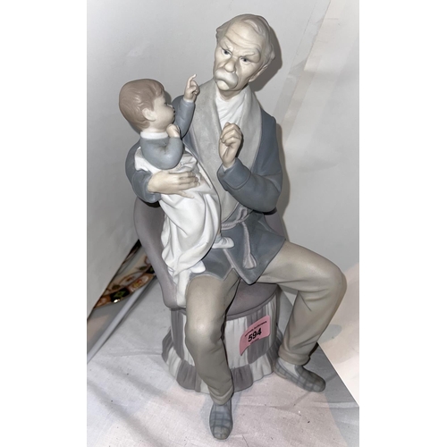 594 - A Lladro bisque figure, grandfather sitting on a chair holding a child (finger a.f.)