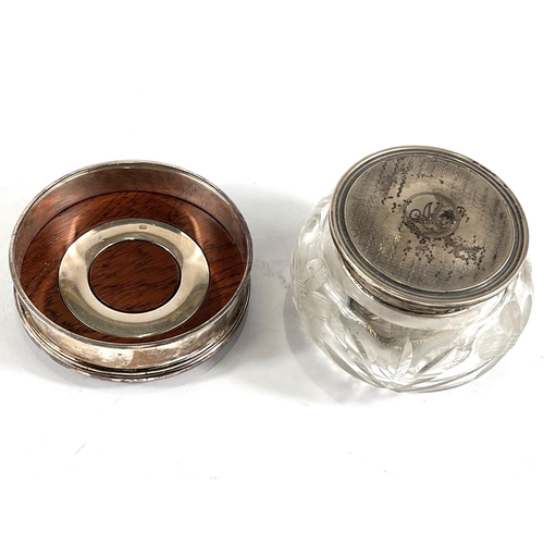 613 - A hallmarked silver coaster by Cars, a silver lidded cut glass trinket jar and a napkin ring