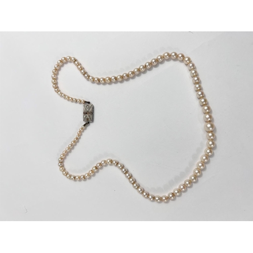 679 - A single strand graduated pearl necklace, with Art Deco style white metal gem set clasp, stamped '9c... 