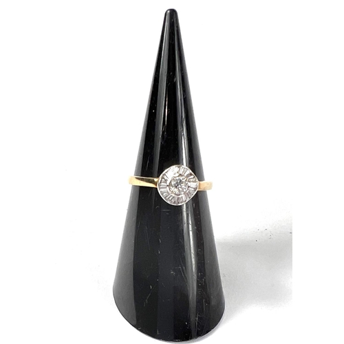 708 - A lady's gold dress ring set with central diamond surrounded by a wavy band of baguette diamonds, ce... 