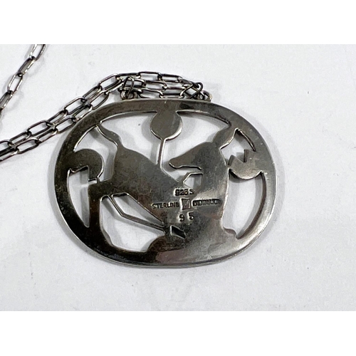 721 - Georg Jensen:  an oval pierced pendant with kneeling deer amongst foliage, numbered 95, stamped... 