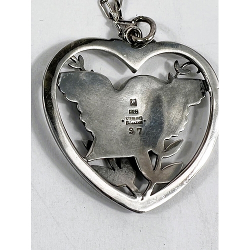 722 - Georg Jensen:  a pierced heart shaped pendant with bird amongst foliage, numbered 97, stamped 9... 