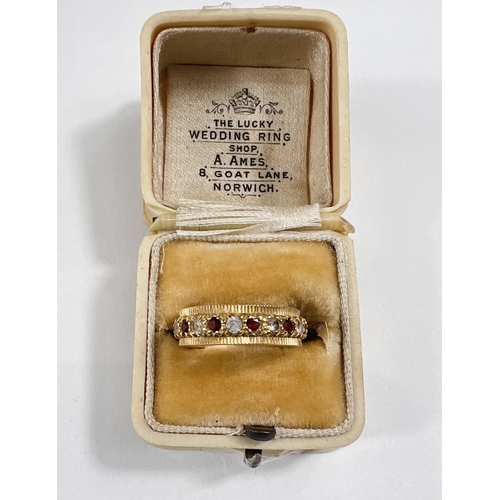 734 - An 18 carat hallmarked gold eternity ring set alternating red and clear stones