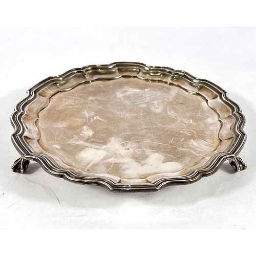 738 - A Georgian-style circular hallmarked silver salver with wavy moulded border and three ball and claw ... 