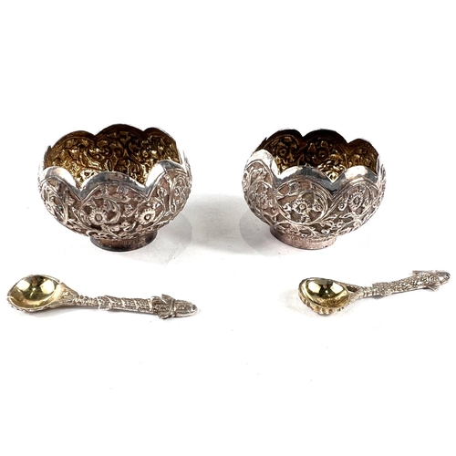 746 - A cased pair of oriental lotus flower shaped white metal salts with extensive relief decoration of s... 