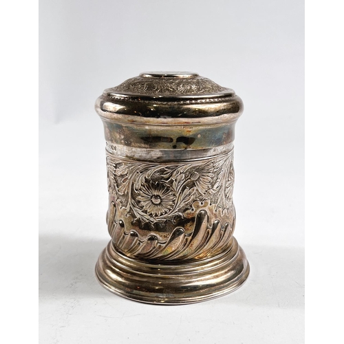 764 - A hallmarked silver cylindrical covered jar with extensive chased and embossed decoration, Sheffield... 