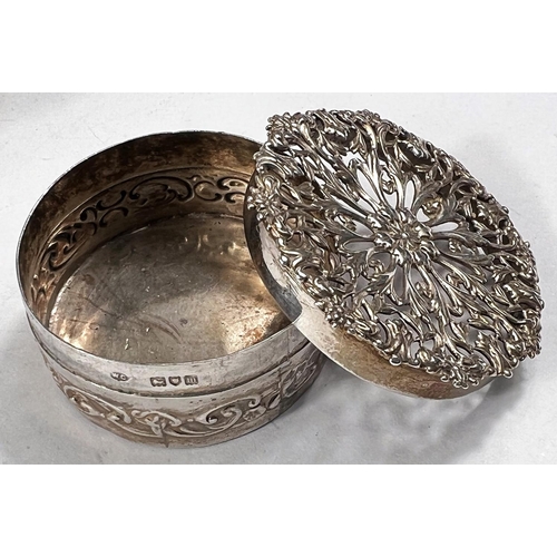 768 - A small circular box the lid with pierced decoration, London 1907, 5cm; a hallmarked silver cir... 