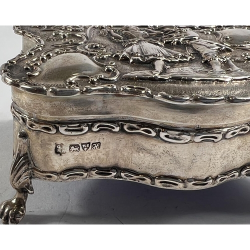 770 - A hallmarked silver shaped rectangular jewellery box, the hinged lid decorated in relief with an 18t... 