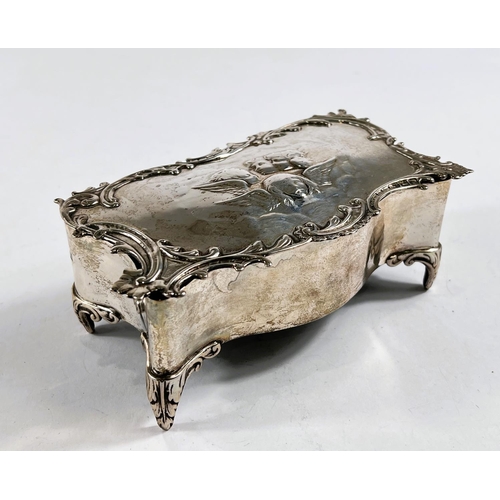 771 - A hallmarked silver shaped rectangular jewellery box, the hinged lid with cherub head relief decorat... 