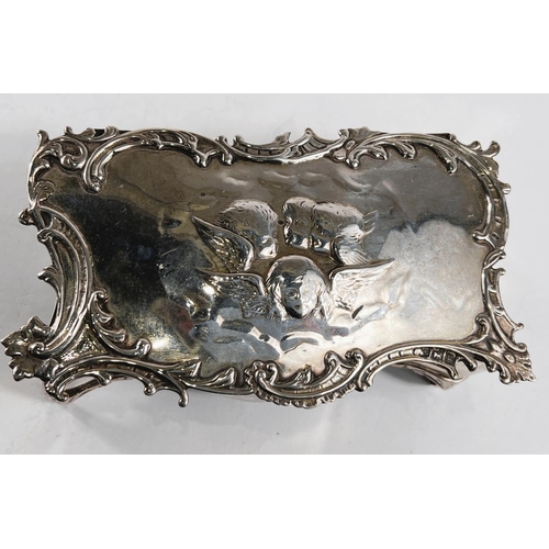 771 - A hallmarked silver shaped rectangular jewellery box, the hinged lid with cherub head relief decorat... 