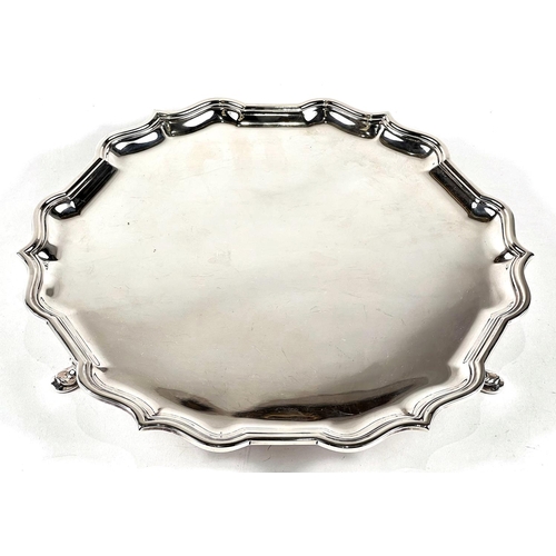 776 - A hallmarked silver circular salver with shaped border, on 3 hoof feet, by Ollivant & Botsford, ... 