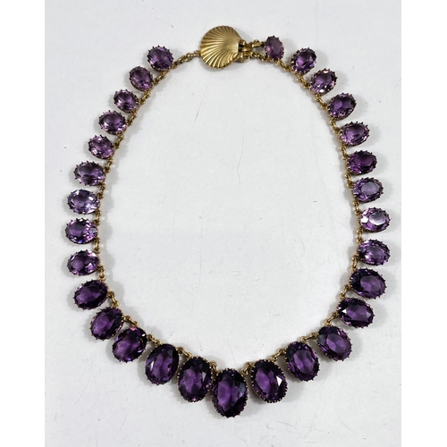 793 - A gilt metal rivière necklace set graduating amethyst coloured stones with shell clasp, stamped 'Nap... 