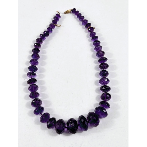 795 - A bead necklace formed from multifaceted graduating amethysts, largest bead diameter 2.5cm, length 5... 