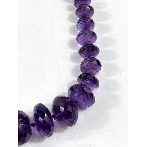 795 - A bead necklace formed from multifaceted graduating amethysts, largest bead diameter 2.5cm, length 5... 