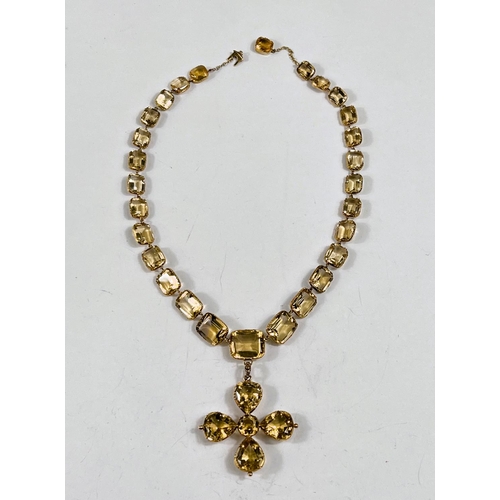 797 - A yellow metal necklace formed from graduating rectangular citrines, each held in an embossed band, ... 