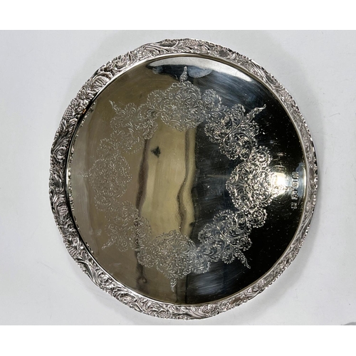 812 - A hallmarked silver circular tray with raised border, relief and chased decoration, Birmingham 1968,... 