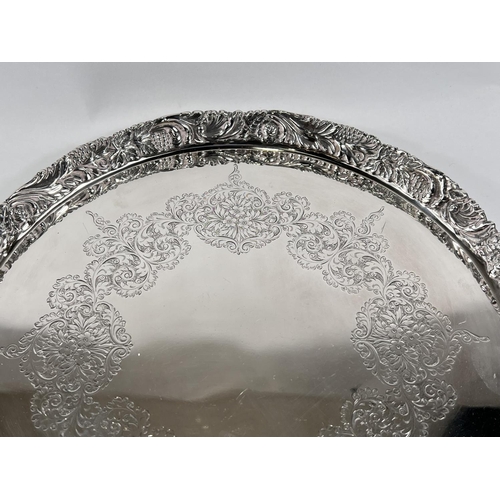 812 - A hallmarked silver circular tray with raised border, relief and chased decoration, Birmingham 1968,... 