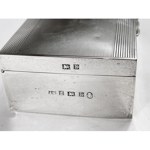 818 - A hallmarked silver rectangular cigarette box, engine turned, Birmingham 1953