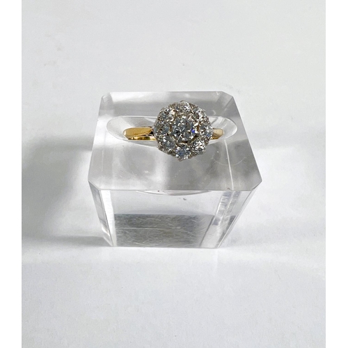 828 - A lady's yellow metal dress ring with diamonds in flowerhead setting, central stone approx. 4mm diam... 