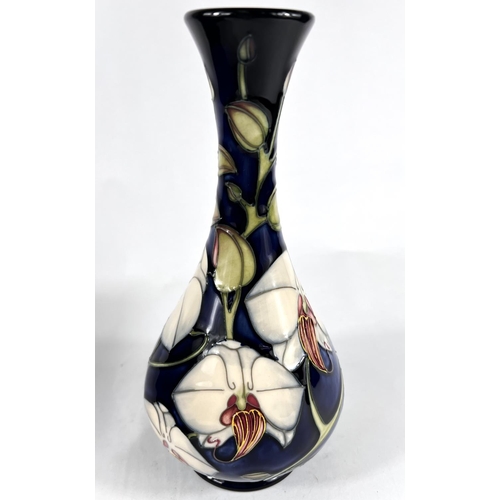 496B - A modern Moorcroft baluster vase with long flared neck, decorated with 'Chatsworth Orchid', against ... 