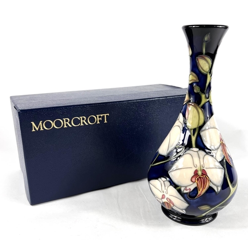 496B - A modern Moorcroft baluster vase with long flared neck, decorated with 'Chatsworth Orchid', against ... 