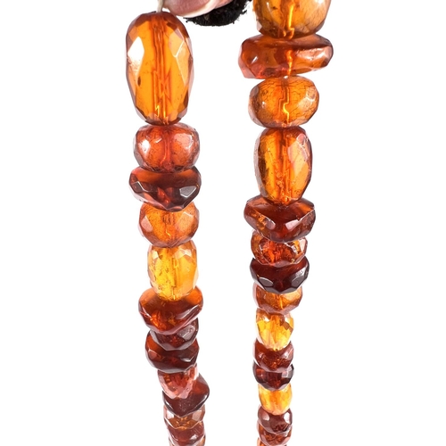 626 - A faceted clear amber necklace of varying shapes and sizes of beads, with white metal clasp with Mid... 