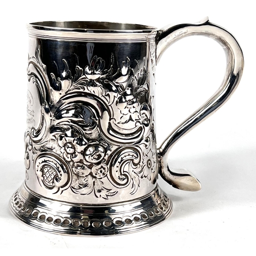 631 - A Georgian hallmarked silver tapering cylindrical 1 pint mug with extensive scroll embossed decorati... 