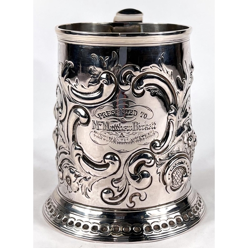 631 - A Georgian hallmarked silver tapering cylindrical 1 pint mug with extensive scroll embossed decorati... 