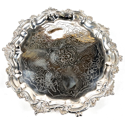 634 - A circular Georgian hallmarked silver salver with scroll and acanthus border and chased centre, on 3... 