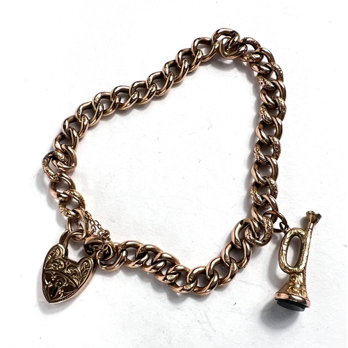 635 - A yellow metal curb chain bracelet stamped '9c', with heart lock and trumpet charm, 12.9gm