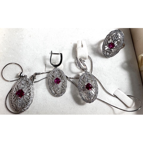 703 - A suite of white metal jewellery stamped 925, necklace, earrings, ring, set with ruby coloured centr... 