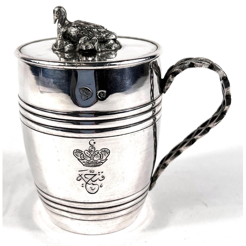 704 - An unusual Middle Easten white metal covered mug in the form of a barrel with sitting duck finial, p... 