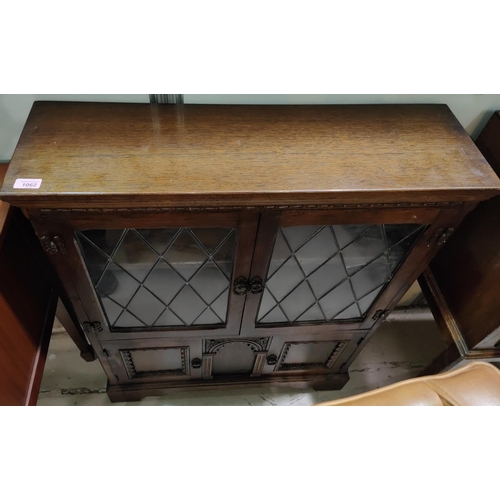 1062 - A Jacobean style oak glazed books case and an oak bureau