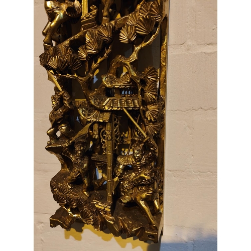 449 - A Chinese carved and pierced gilt wood wall hanging decoration, wit warriors fighting below a temple... 