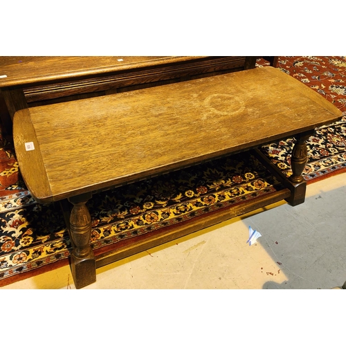 938 - An oak traditional style coffee table with carved legs, a 1930's oak armchair with tapering legs