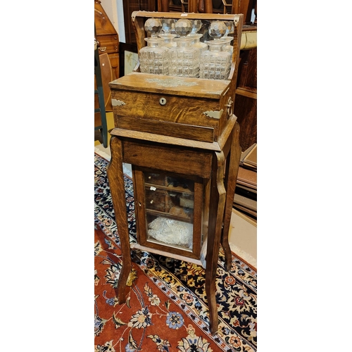 971 - An Edwardian oak free-standing tantalus, games box and smokers cabinet with hinged fitted top and 3 ... 