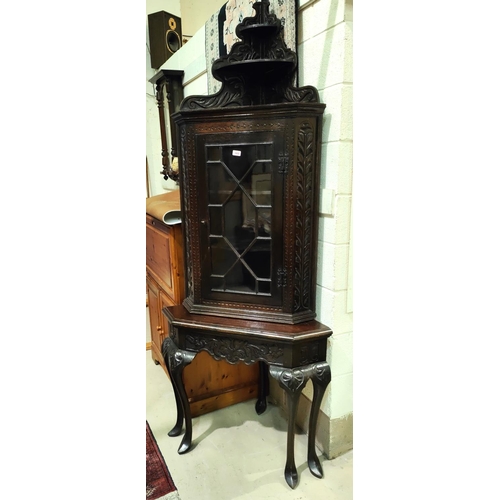 1033 - A large Victorian full height carved oak corner cupboard on stand with astragal glazed door, shelves... 