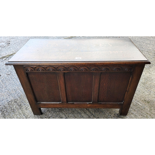 1042 - A carved golden oak bedding chest with panelled front 